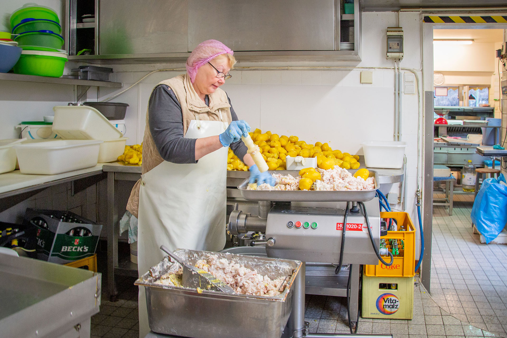 Eine Frau stampft Kartoffeln.