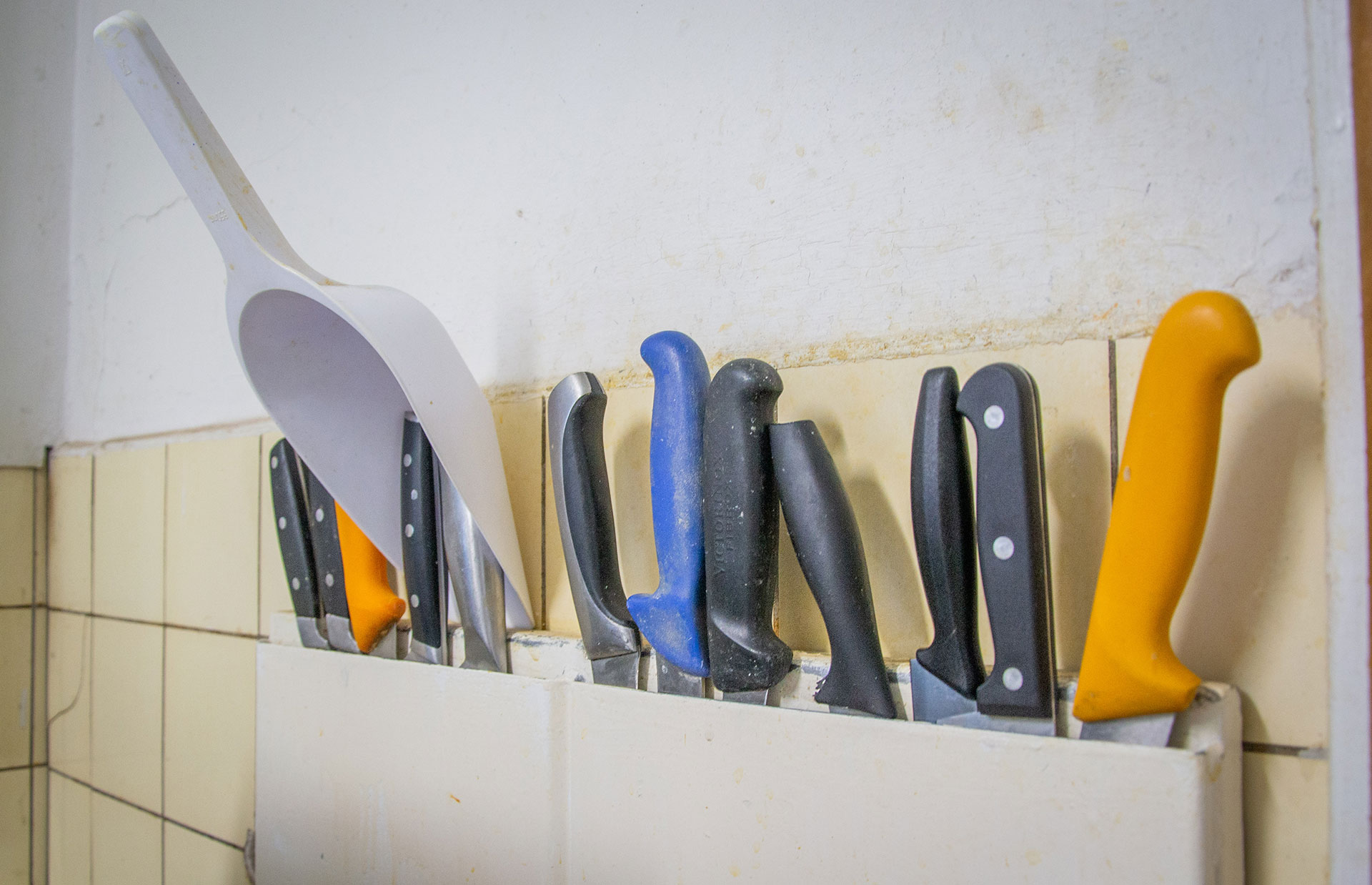 Messer stehen in einer Halterung an einer Wand.