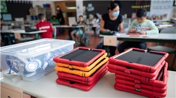 Tablets liegen in einer Grundschule vor einer Klasse.