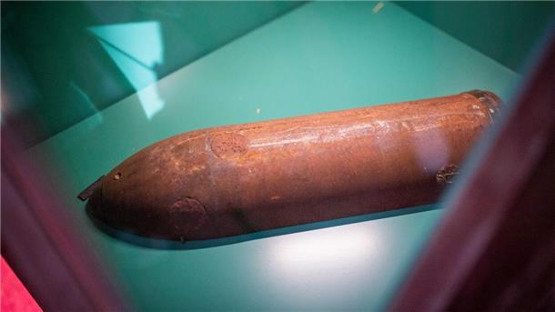 Eine Patronenhülse liegt in einer Vitrine