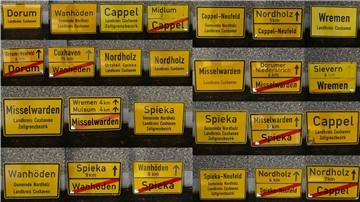 13 Ortstafeln (die Fotomontage zeigt Vor- und Rückseiten) aus der ehemaligen Samtgemeinde Land Wursten sowie der Gemeinde Nordholz.