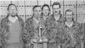 Fünf Männer mit einem Pokal