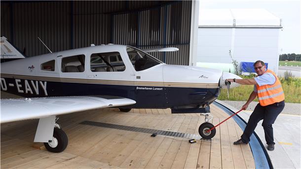 Markus Brandes, Vorsitzender des Aero Clubs Bremerhaven, zieht eine Schulungsmaschine aus dem Rundhangar des Flugplatzes Nordholz. 
