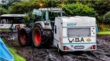 Ab durch den Schlamm: Ein Traktor zieht einen Wohnwagen vom Campinggelände des Wacken Open Air.