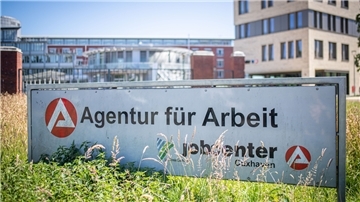 Ein Schild mit der Aufschrift "Agentur für Arbeit" steht in Bremerhaven vor dem Jobcenter.