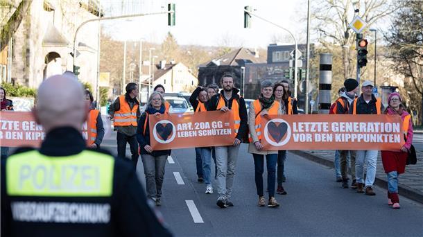 Klimaaktivisten sorgen mit Protestmarsch für Stau Aktivisten der Bewegung „Letzte Generation“ gehen mit Plakaten bei einem friedlichen Protestmarsch über eine Hauptverkehrsstraße.