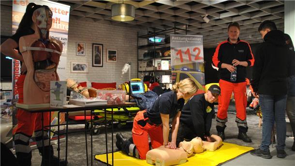 Alina Feith und Thies Neckritz legen sich am Stand des Rettungsdienstes mit der Reanimationspuppe ins Zeug.