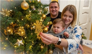Am Weihnachtsbaum der Bremerhavener Tafel feiern die ukrainischen Flüchtlinge Olya und Pavel Fedorenko mit ihrem Söhnchen David, der als erstes ukrainisches Flüchtlingsbaby in Bremerhaven zur Welt kam.