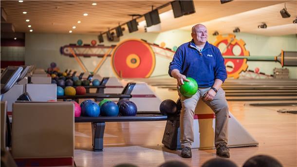 Ein Mann auf einer Bowlingbahn.