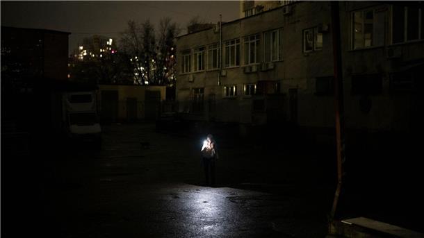 Alltag in Kiew: Eine Frau benutzt die Beleuchtung ihres Handys, um den Weg zu finden.