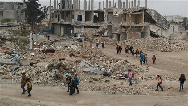 Alltag in Syrien: Kinder auf dem Rückweg von der Schule - sie laufen an Gebäuden vorbei, die durch Luftangriffe zerstört wurden.