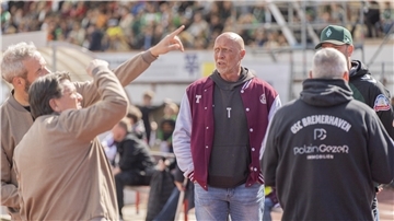 Ein Fußball-Trainer wartet am Spielfeldrand auf den Anpfiff.