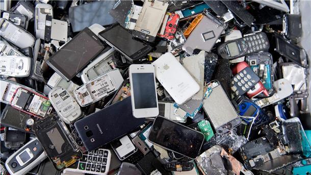 Recycling: Rohstoffe aus der urbanen Mine immer wichtiger Alte Handys und Smartphones liegen in einem Container, ehe sie geschreddert werden.