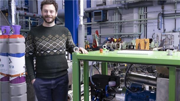 Hochschullehrer Peter Seedorf steht neben dem Wasserstoffmotor