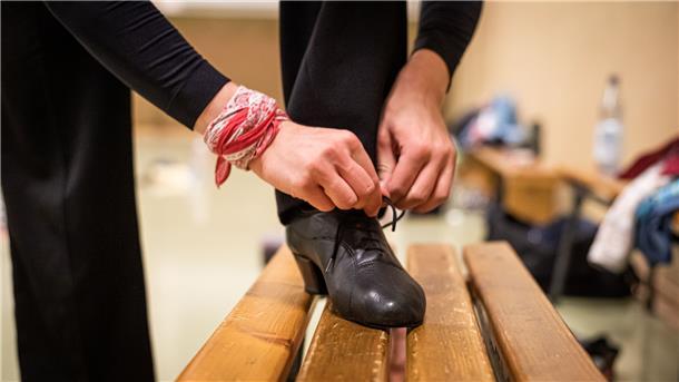 Tänzer schnürt sich die Schuhe.