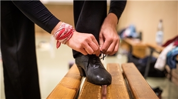 Tänzer schnürt sich die Schuhe.