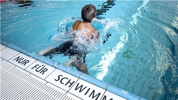 Ein Kind schwimmt in einem Schwimbad.