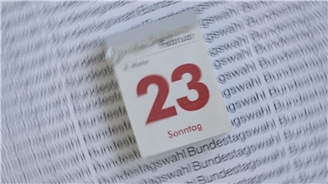 Das Foto zeigt einen Abreißkalender, der den 23. Februar 2025 anzeigt. Dahinter ist ein weißes Blatt Papier mit der mehrfachen Aufschrift Bundestagswahl zu sehen.
