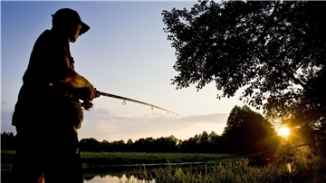 Ein Angler im Sonnenuntergang. Am 7. September lädt das Natureum in Balje zum Angelflohmarkt mit Rahmenprogramm für die ganze Familie ein.