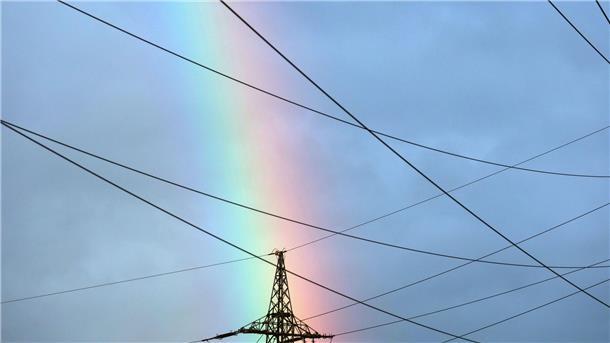 Am Ende des Regenbogens steht ein Strommast? Die bunten Farben leuchen am Morgen am Himmel über Würzburg.