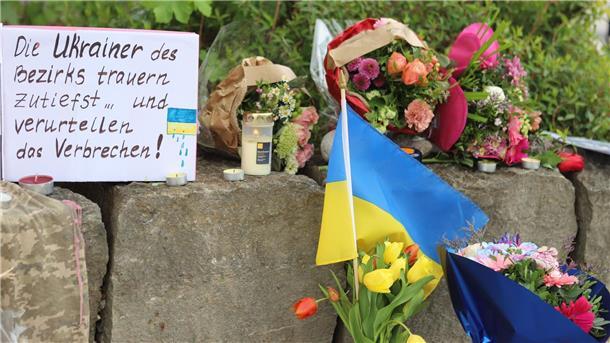 Ukrainer getötet - Generalstaatsanwaltschaft ermittelt Am Gelände eines Einkaufszentrums, an dem zwei Männer aus der Ukraine getötet worden sind, wurden Blumen niedergelegt sowie eine kleine ukrainische Flagge aufgestellt.