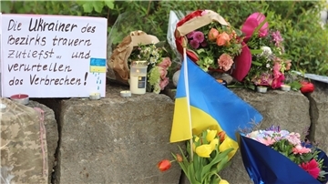 Am Gelände eines Einkaufszentrums, an dem zwei Männer aus der Ukraine getötet worden sind, wurden Blumen niedergelegt sowie eine kleine ukrainische Flagge aufgestellt.