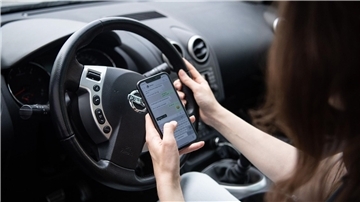 Am Handy sein, während man Auto fährt, ist verboten.
