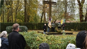 Menschen sind rund um ein großes Kreuz versammelt