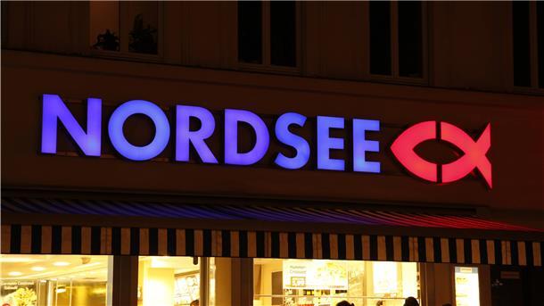 Die Leuchtschrift des Unternehmens "Nordsee" leuchtet im Dunklen. 