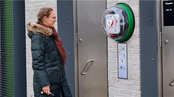 Am Nordenhamer Bahnhofsvorplatz, zwischen Fahrrad-Unterstand und WC-Anlagen, hängt ein neuer Defibrillator.