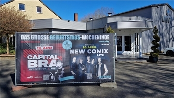 Ein großes Werbeschild von der Eingangstür einer Diskothek.