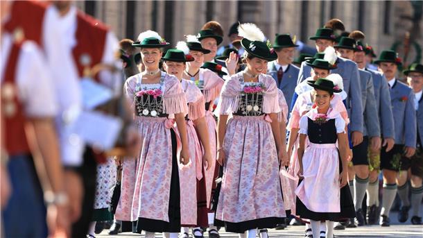 Lustige Tänzer und traditionelle Kleider Am Sonntag zogen viele Leute in traditionellen Trachten durch München zum Oktoberfest.