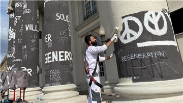 Am Tag nach dem Ende der documenta fifteen werden die Säulen des Fridericianums in Kassel übermalt.