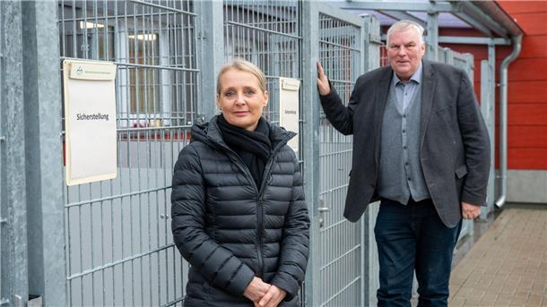 Zwei Personen vor einem Tierkäfig