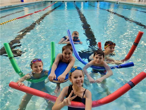 Kinder planschen im Becken. 