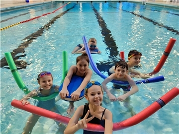 Kinder planschen im Becken. 