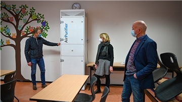 An der Oberschule im Schulzentrum Carl von Ossietzky sind Luftreiniger aufgestellt worden. Der technische Leiter von Seestadt Immobilien Holger Schneeberg erklärt Ulrike Baumgart-Gruhn und Georg Mondwurf (von links) die Funktion.