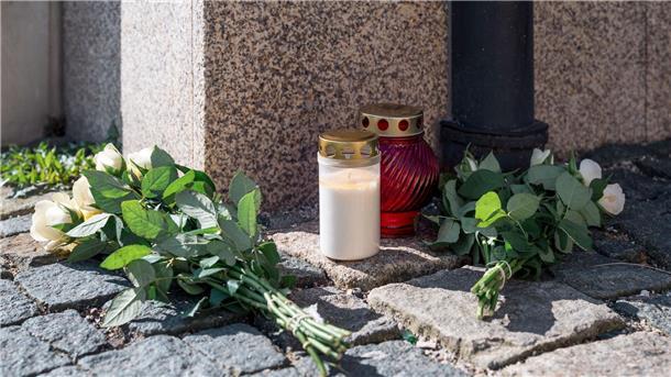 An der Straßenecke zur Zufahrt zum Kinder- und Jugendhilfezentrum, in dem eine Zehnjährige tot aufgefunden wurde, liegen weiße Rosen und Grablichter auf dem Gehweg.