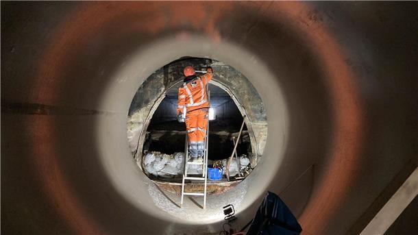An der Westseite der Autobahn führt das neue Kunststoffrohr an einen alten Ausgang aus Beton, der weiter genutzt wird. Er soll noch von Schlamm befreit werden. 
