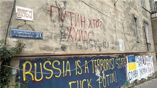 An einer Hauswand in einem Viertel der Hauptstadt Tiflis stehen auf Englisch und auf Ukrainisch antirussische Parolen, die den Krieg von Kremlchef Wladimir Putin gegen die Ukraine verurteilen.