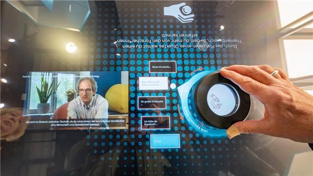An Multimedia-Tischen können Besucher Videos abrufen: Wissenschaftler erklären Projekte zur Energiewende aus ihrem Bereich und beantworten auch die Frage, was sie verändern würden, wenn sie Superkräfte hätten.