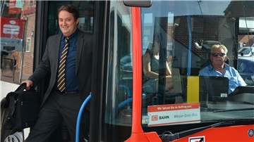 Mann steigt aus einem Linienbus