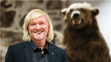 Andreas Kieling 2020 bei der Vernissage zu seiner Ausstellung „Mit den Grizzlys durch Alaska“ neben einem Präparat eines Grizzlybären.