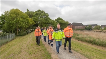 Menschen laufen auf dem Geeste-Deich. Andreas Krause (links) und EBB-Vorstand Markus Kamps (rechts) führen die Gruppe bei der Deichschau in Bremerhaven an.