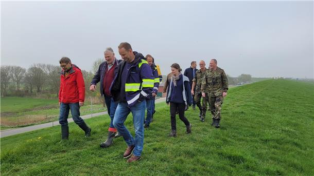 Andreas Lesch (links) vom Landkreis Cuxhaven nimmt den nördlichen Teil des Wurster Seedeichs gemeinsam mit den Vertretern von Deichverbänden, weiteren Behördenvertretern und der Bundeswehr unter die Lupe.