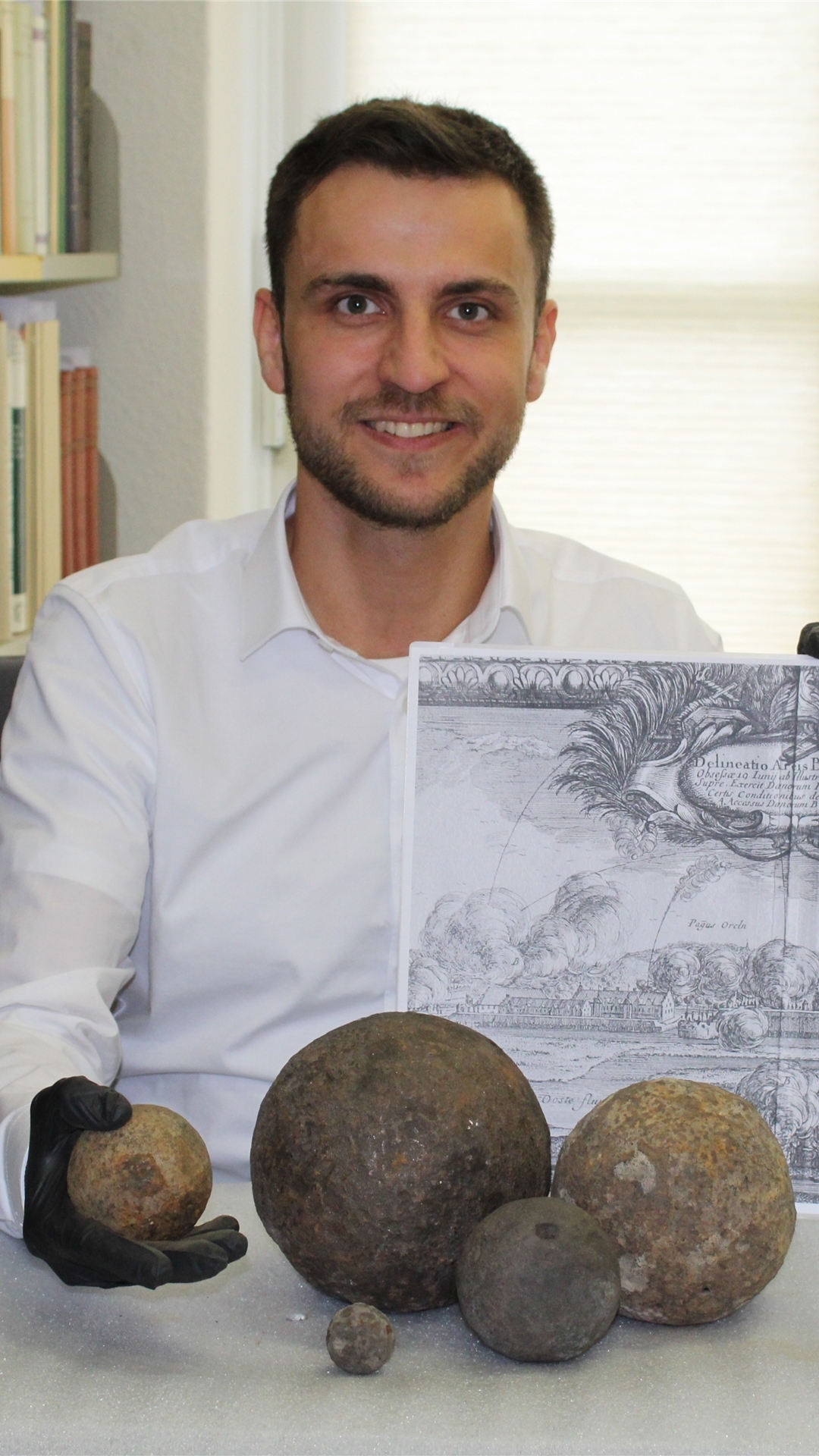 Andreas Schley mit Kanonenkugeln und einem Kupferstich der Belagerung des Schlosses Bremervörde im Jahre 1657, auf dem der Einsatz von Kanonen zu sehen ist.