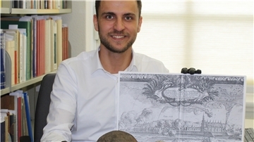 Andreas Schley mit Kanonenkugeln und einem Kupferstich der Belagerung des Schlosses Bremervörde im Jahre 1657, auf dem der Einsatz von Kanonen zu sehen ist.
