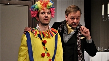 Andrew Wyke (Andras Brendel, rechts) hat seinen Rivalen Milo Tindle (Maciej Tyrakowski) in ein Clownskostüm gesteckt. In der Krimikömödie „Revanche“ geht es turbulent zu.