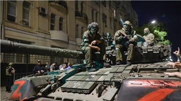Angehörige des Militärunternehmens Wagner Group sitzen auf einem Panzer auf einer Straße in Rostow am Don, Russland, bevor sie einen Bereich im Hauptquartier des südlichen Militärbezirks verlassen.