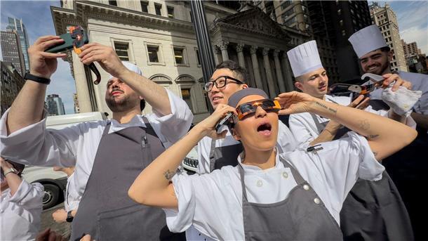 Angestellte eines Restaurants in Manhattan machen eine Pause, um die Sonnenfinsternis zu betrachten.